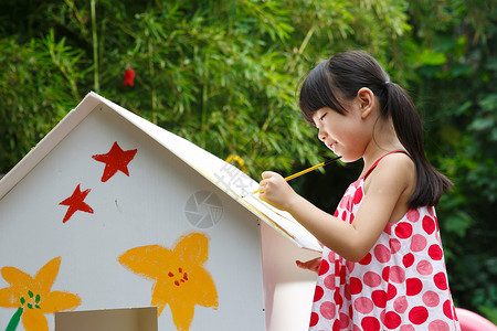 拿着画笔的女孩幼儿园里的小女孩在作画背景