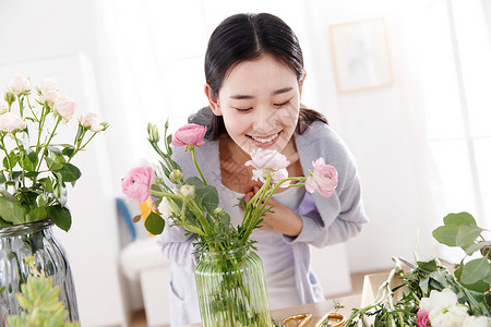 气味芳香青年女人在闻鲜花的香味背景