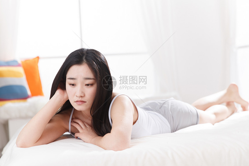 青年女人在卧室的床上图片