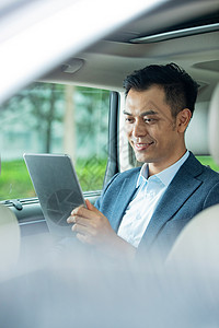 运输选择商务男士坐在汽车里看平板电脑背景