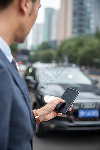 商务男士在商业区用手机软件打车背景