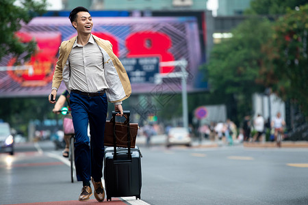 马路上拉着行李追赶汽车的商务男子图片