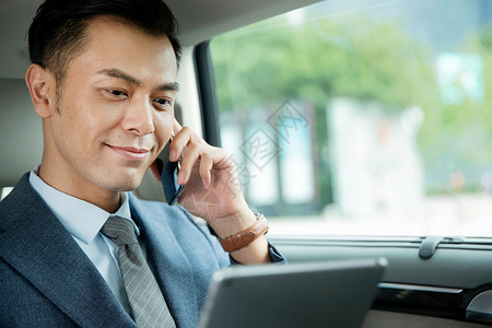 运输选择商务男士拿着平板电脑打电话沟通工作背景