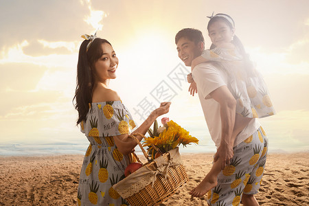 幸福的一家三口在沙滩上散步图片