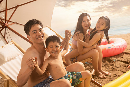 沙滩上坐凉椅的幸福家庭高清图片