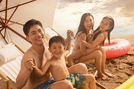 沙滩上坐凉椅的幸福家庭高清图片