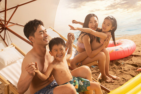 沙滩上坐沙滩椅的幸福家庭图片