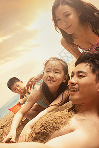 沙滩上男人和妻子孩子自拍图片