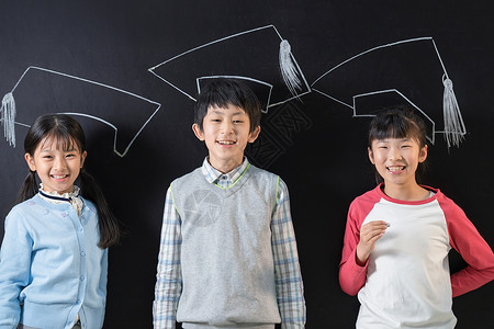 戴博士帽男孩站在黑板前的快乐小学生背景