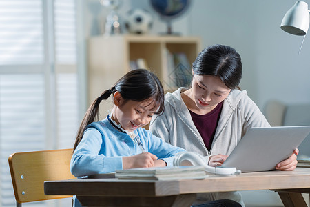 电子作业年轻妈妈辅导女儿学习背景