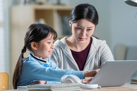 电子作业年轻妈妈辅导女儿学习背景