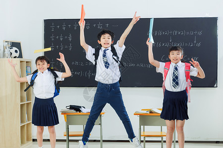 快乐的小学生在教室里欢呼跳跃高清图片