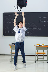 向上跳跃男孩快乐的小学男生在教室里欢呼跳跃背景