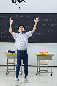 快乐的小学男生在教室里欢呼跳跃高清图片