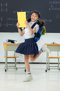 黄色裙子的女生快乐的小学女生在教室里欢呼跳跃背景