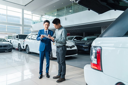 产业投资青年男人与汽车销售人员签订合同背景