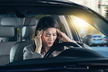 开车表情头痛的青年女人驾驶汽车背景