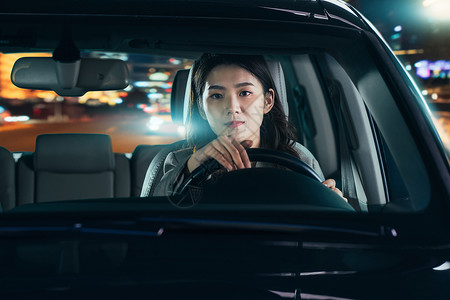 夜晚驾驶汽车的青年女人高清图片