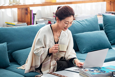 爱格杂志素材优雅的中老年女士在家使用笔记本电脑背景