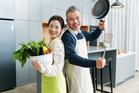 平底锅和铲子中老年夫妇在厨房做饭背景