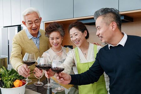 快乐的中老年人在厨房举杯庆祝高清图片