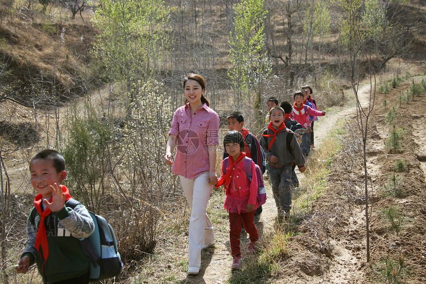 乡村老师和学生走在山路上图片