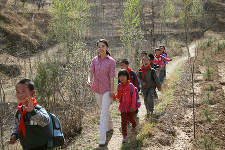 乡村老师和学生走在山路上图片