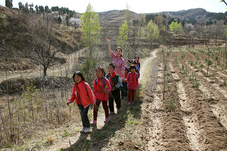 乡村老师和学生走在山路上图片