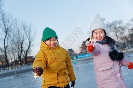 拿着雪球的人快乐儿童在溜冰场放烟花背景