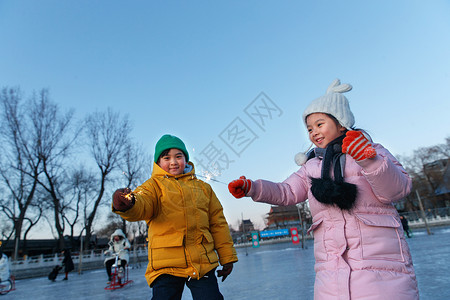 冬季在外面女孩快乐儿童在溜冰场放烟花背景