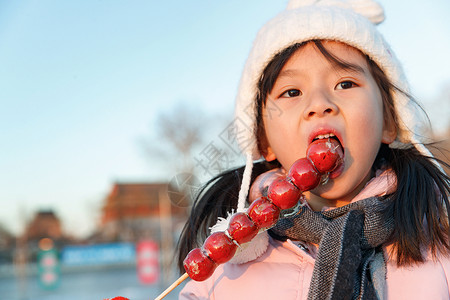 快乐的小女孩吃糖葫芦高清图片