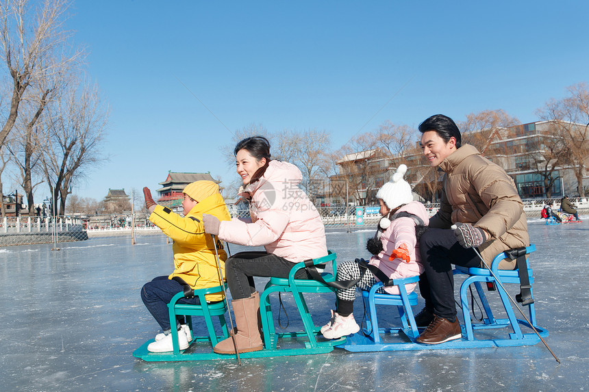 快乐的一家四口坐冰车玩耍图片