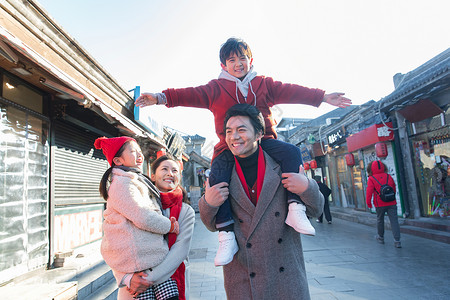 青年夫妇带着孩子逛街购物图片