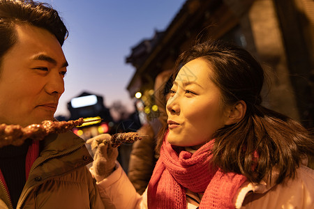 青年夫妇逛街吃羊肉串图片