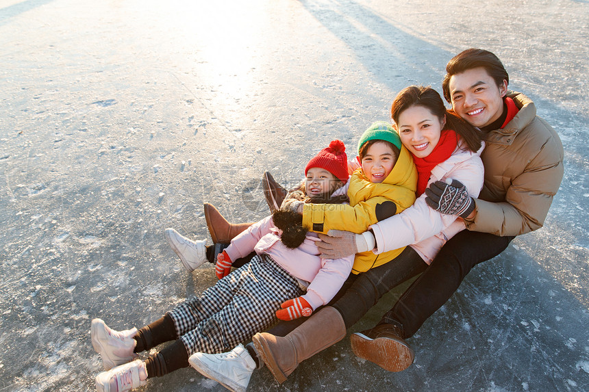 快乐的一家四口坐在冰面上玩耍图片