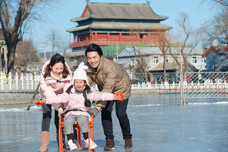 冰雪文化快乐的一家三口坐冰车玩耍背景