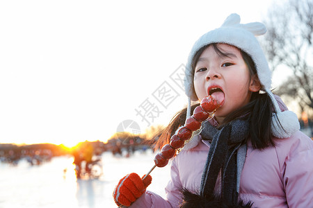 快乐的小女孩吃糖葫芦高清图片