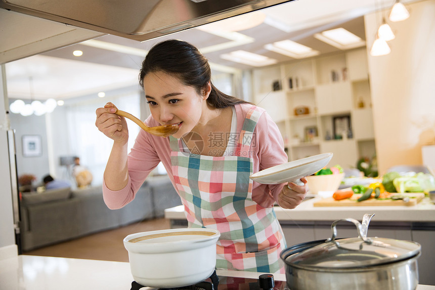 青年女人在厨房煲汤图片