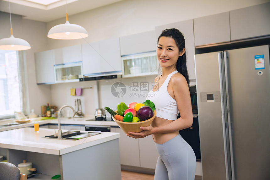 穿着运动装的青年女人在厨房图片