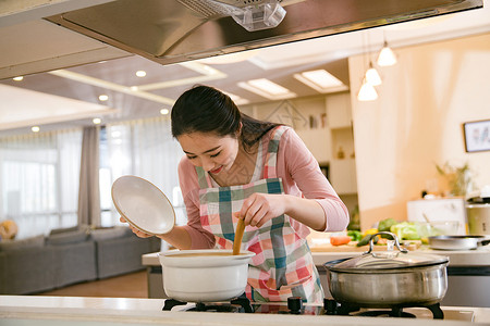 围裙锅具青年女人在厨房煲汤背景