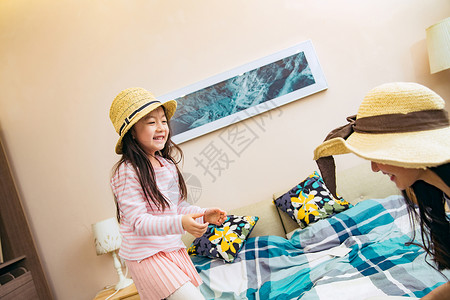 装饰帽母亲和女儿在卧室玩耍背景