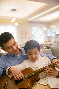 演凑父亲和男孩在弹吉他背景