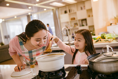 年轻妈妈和女儿在厨房高清图片