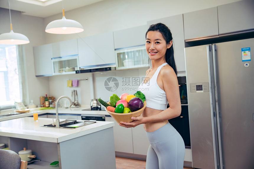 穿着运动装的青年女人在厨房图片