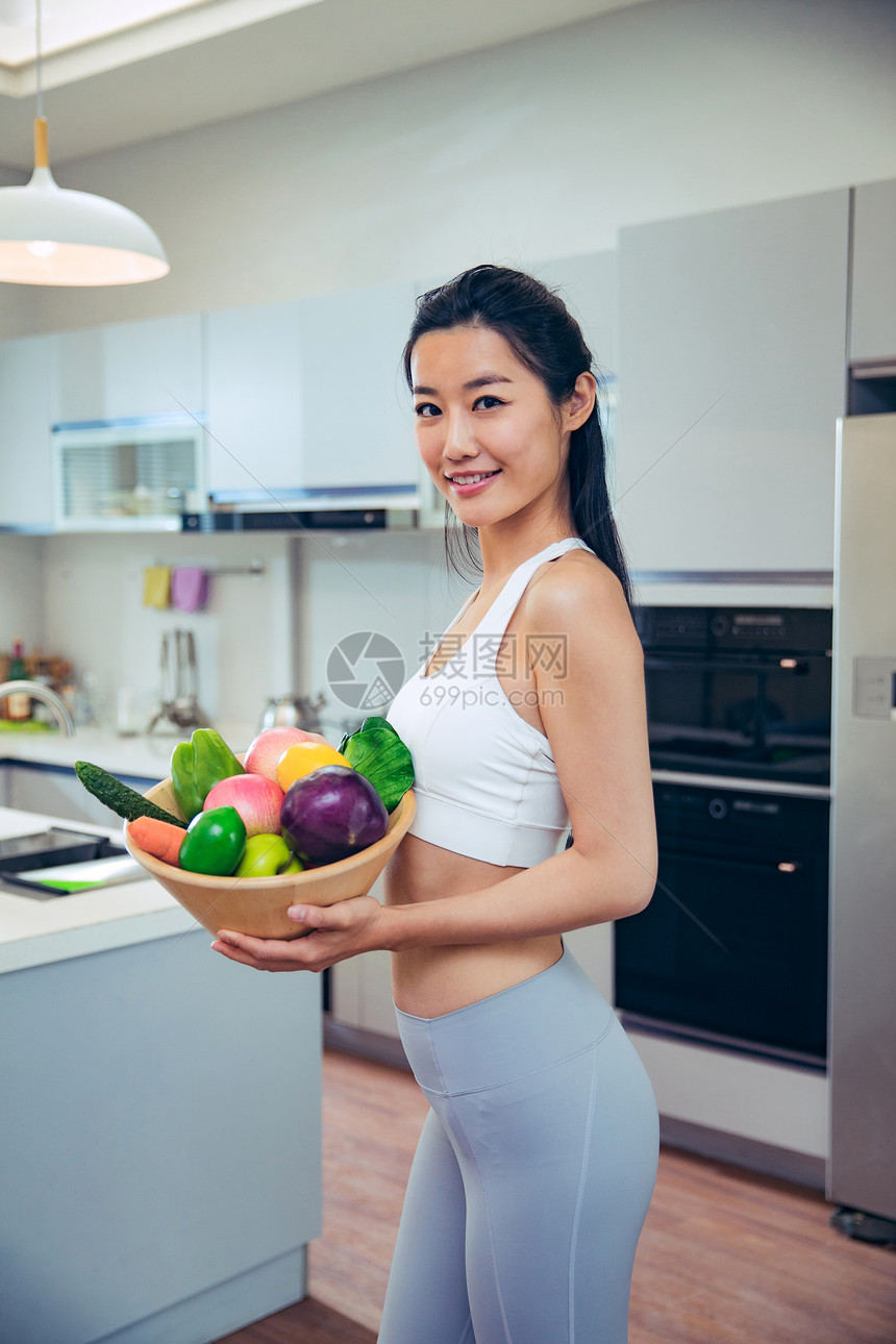 穿着运动装的青年女人在厨房图片