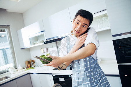 青年男人在厨房打电话高清图片