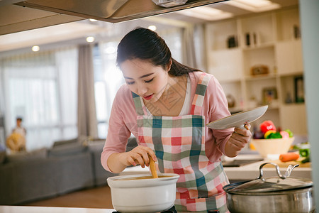 青年女人在厨房煲汤图片