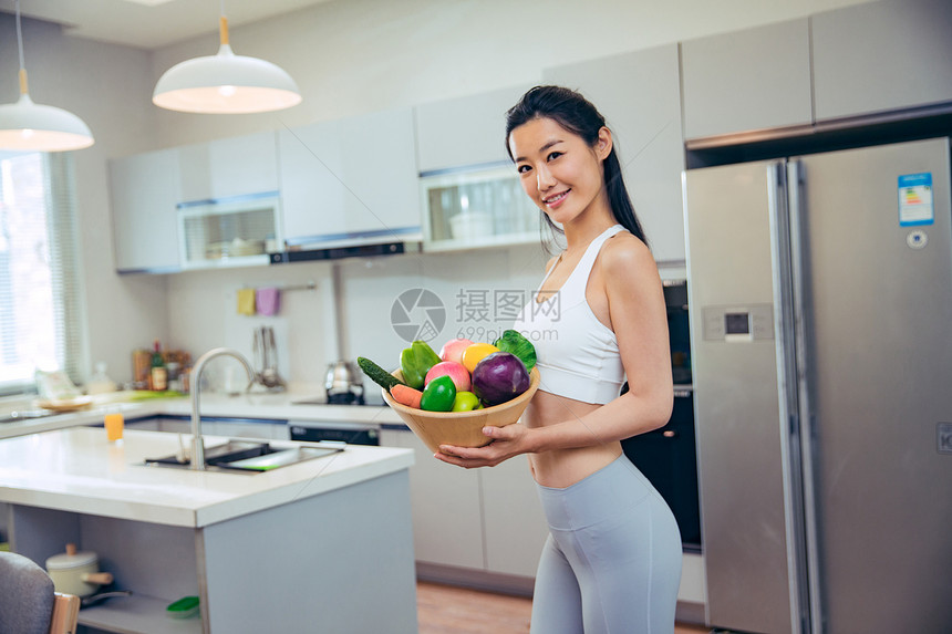 穿着运动装的青年女人在厨房图片