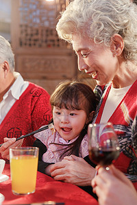 餐桌上祖母喂孙女吃饭高清图片