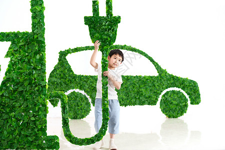 快乐的小男孩给新能源汽车充电图片